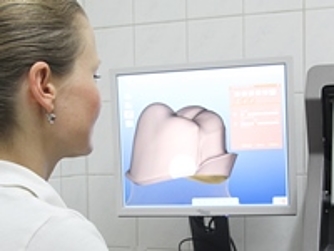 Ärztin mit Zahnmodell auf dem Computer